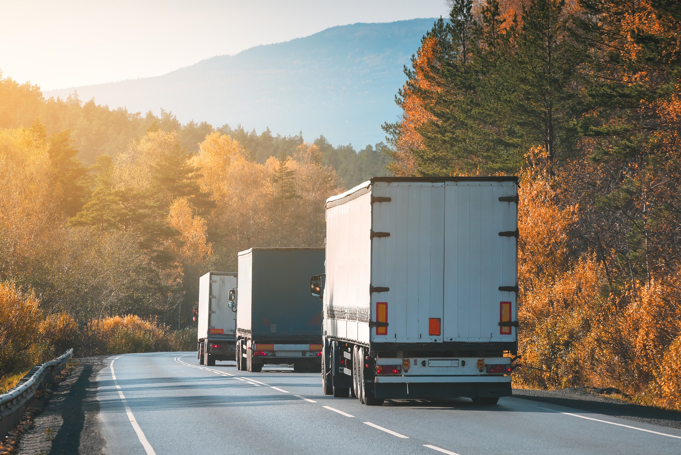 Freight trucks on the autumn road.